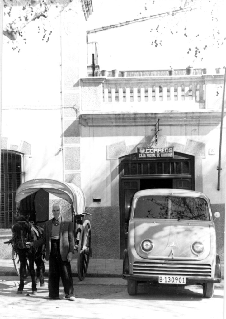 Un carro i una furgoneta aparcats davant l’edifici de correus a la pl. d’Ocata, 1957. Arxiu Municipal del Masnou, 1426.